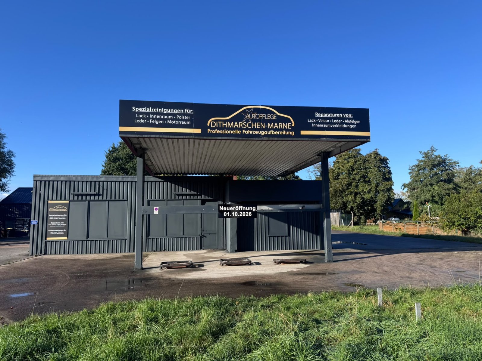 Einfahrt der Autopflege Dithmarschen Marne mit dem Firmenbanner